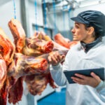 Butcher using technology in a innovative meat processing factory
