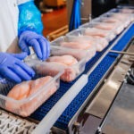 Line for the production of meat with packaging and cutting . Industrial equipment at a meat factory. Meat processing plant. Production line of meat.